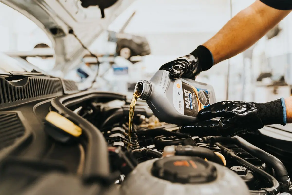 Motor yağı dolumu yapan servis teknisyeni
